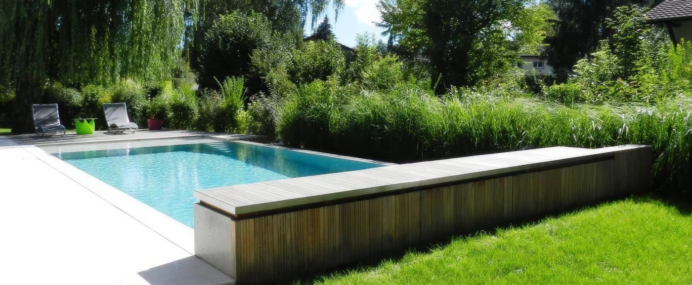 Piscine à débordement, pierre grise et bois exotique