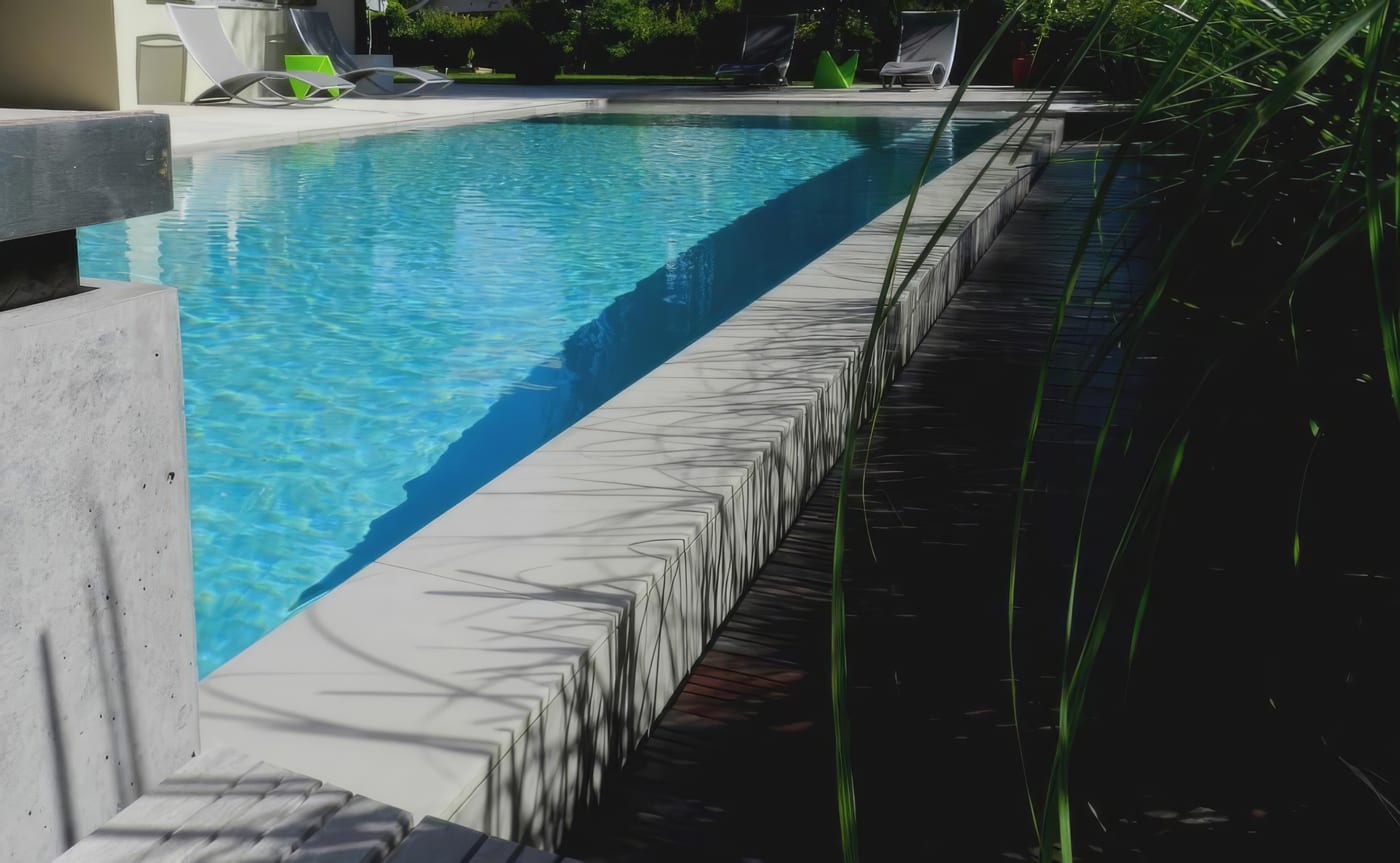 Piscine à débordement, pierre claire et liner bleu