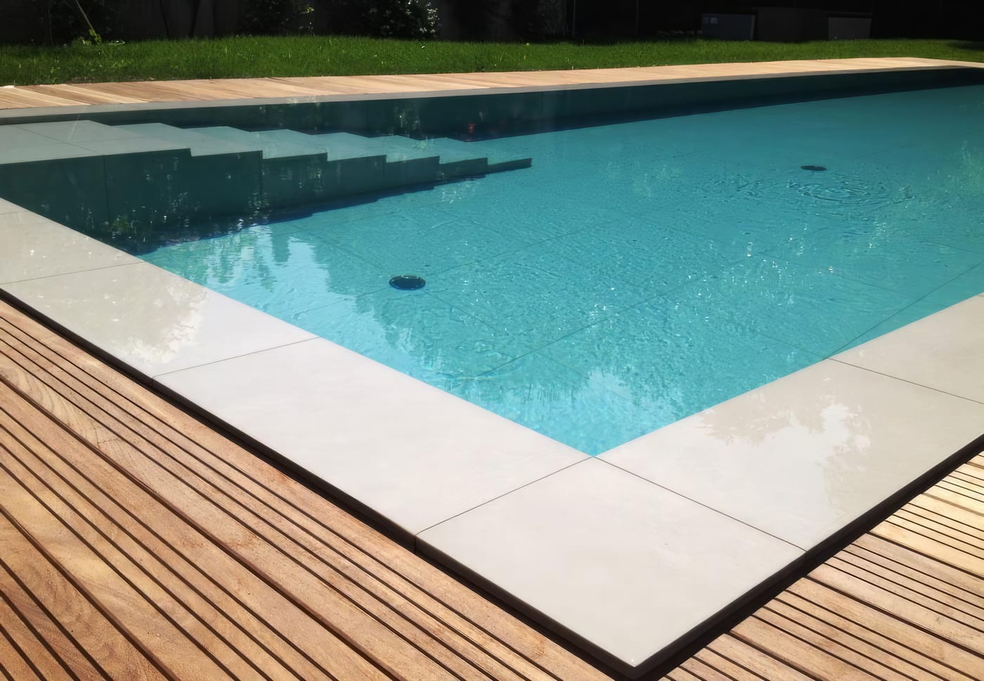 Piscine miroir, pierre claire et bois exotique