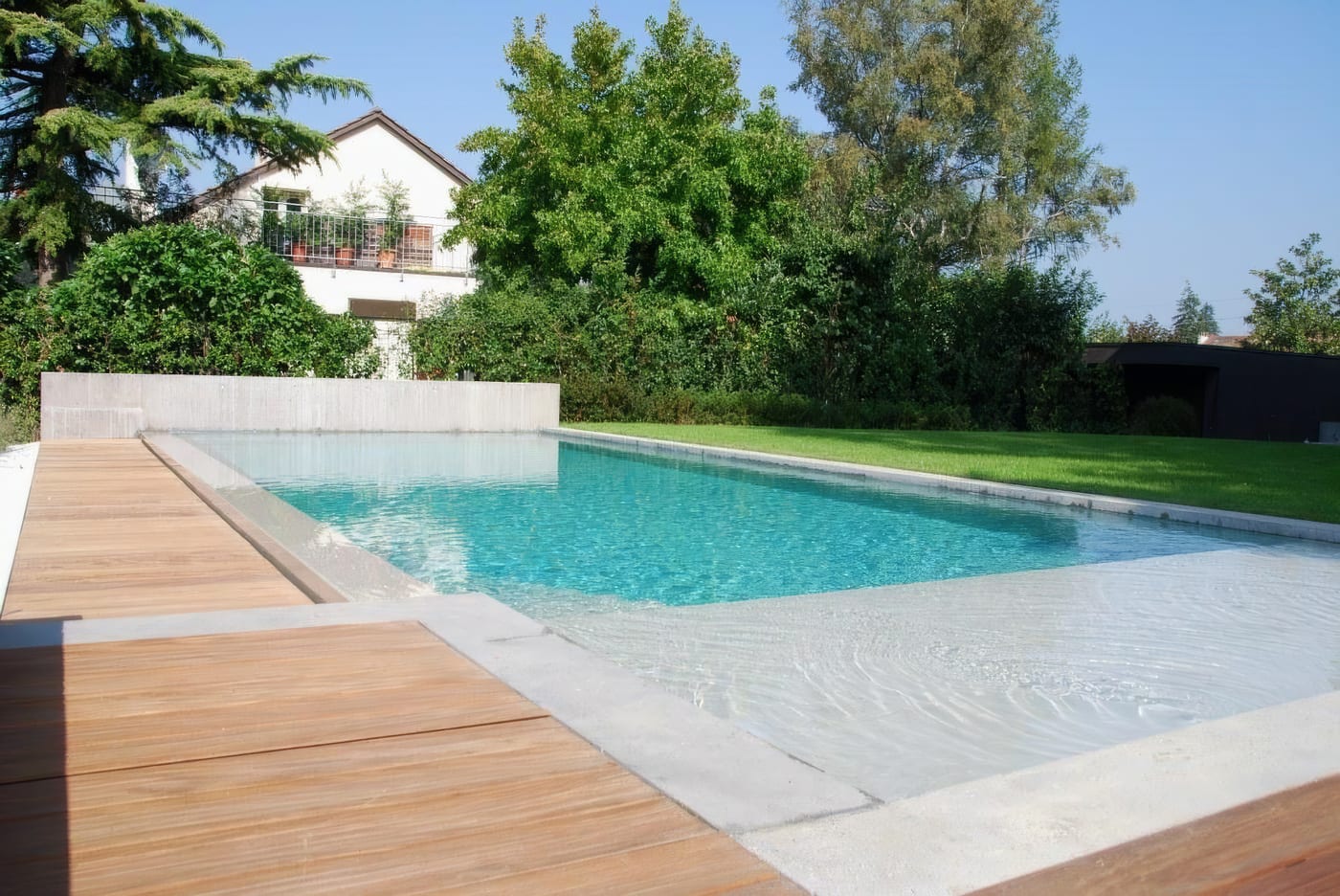 Piscine à débordement, béton ciré et pierre claire