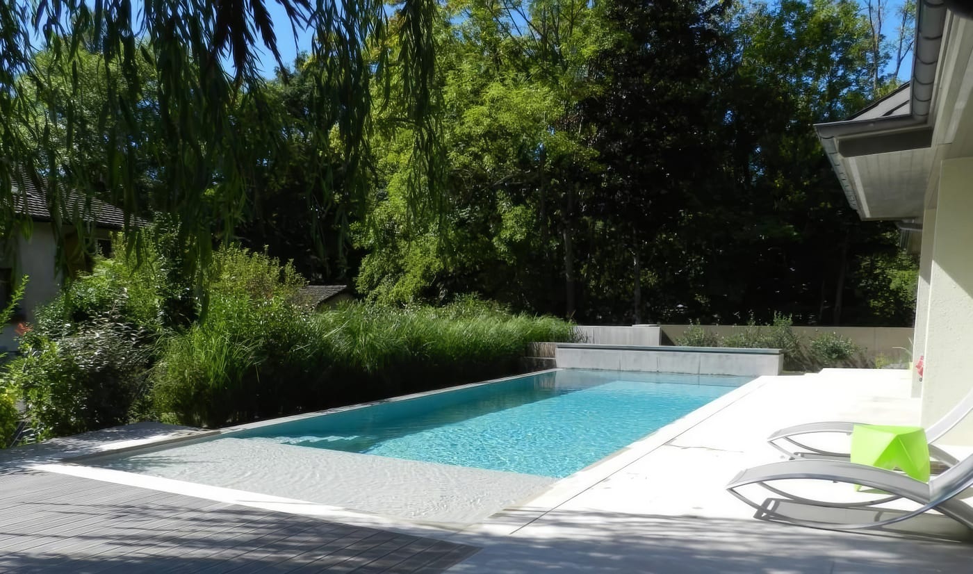 Piscine à débordement, pierre blanche et liner gris