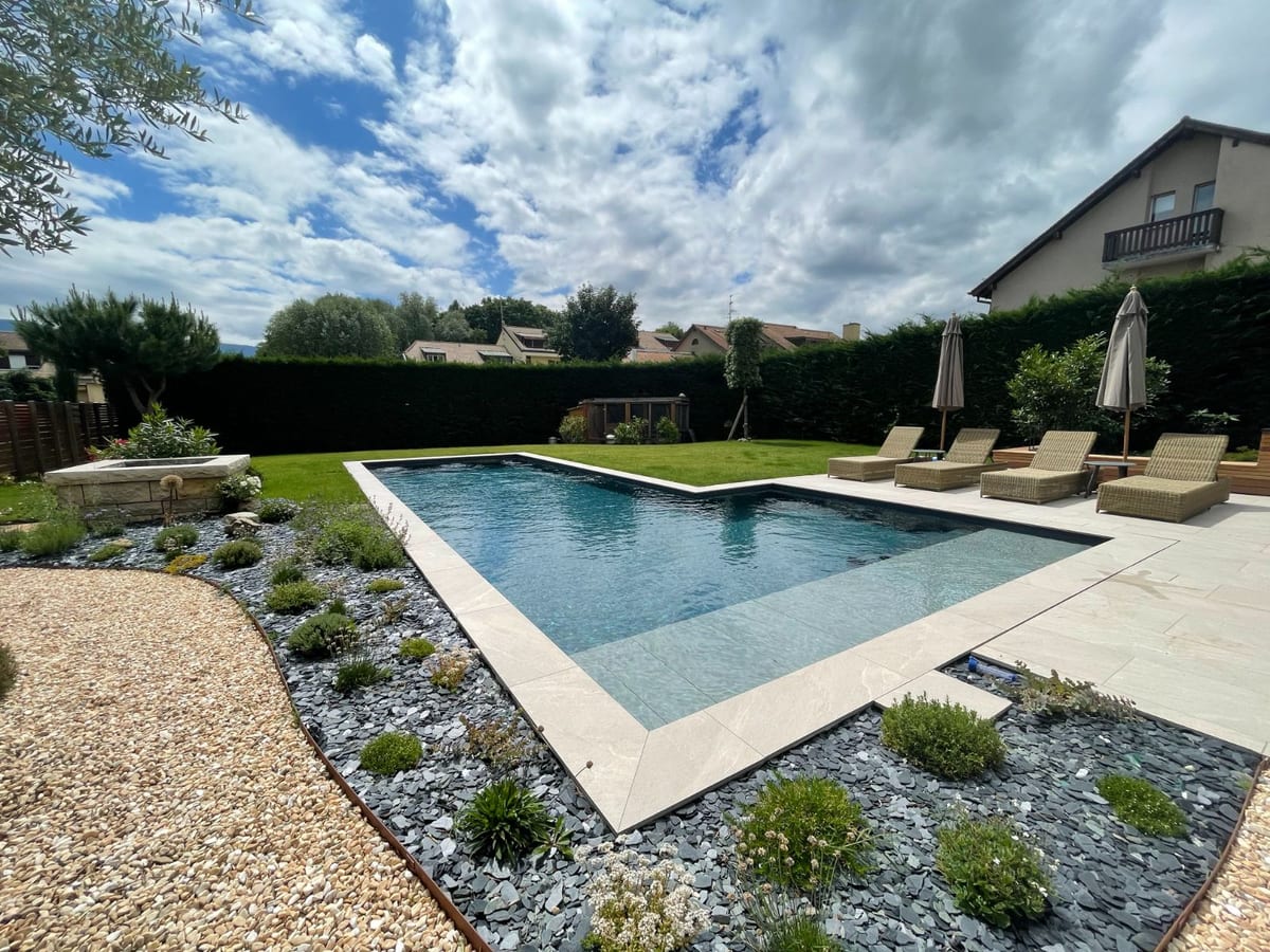 Piscine traditionnelle entre terrasse en pierre et bassin