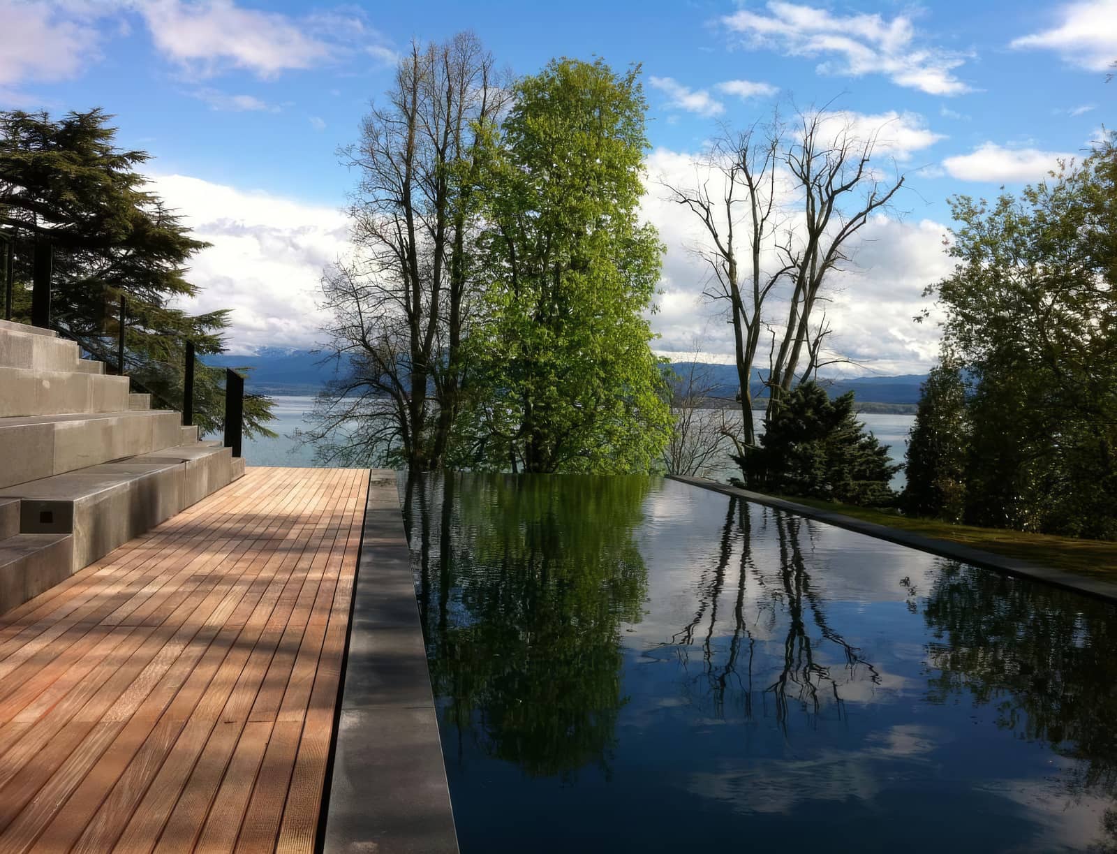 Piscine à débordement, terrasse en bois, vue sur le lac Léman